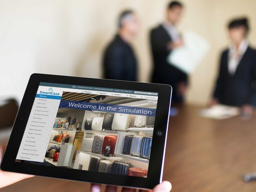 Tablet held up showing welcome page for corporate simulation, participants in background