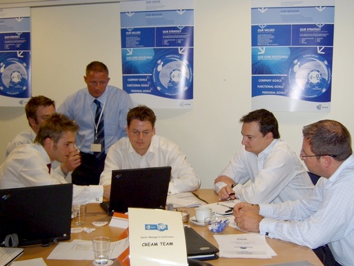 Participants at a team-building workshop using a simulation on laptops