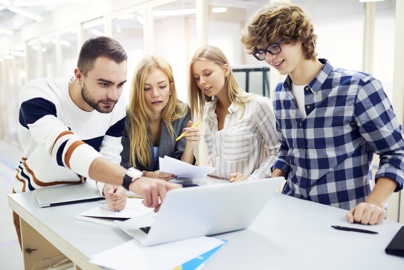 Four team members working around laptop