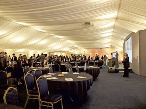 Business students in huge marquee receiving simulation results